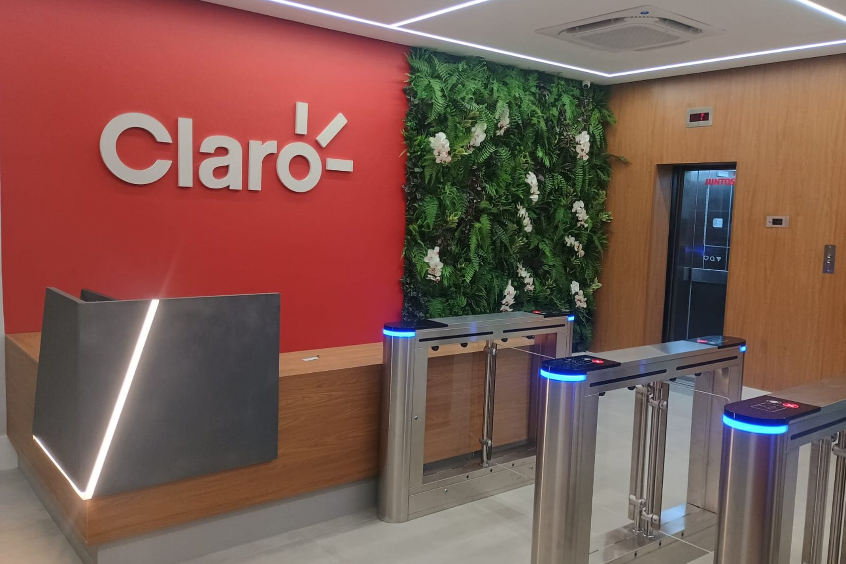 RECEPÇÃO — Recepção com a marca Claro, parede verde e iluminação linear nova